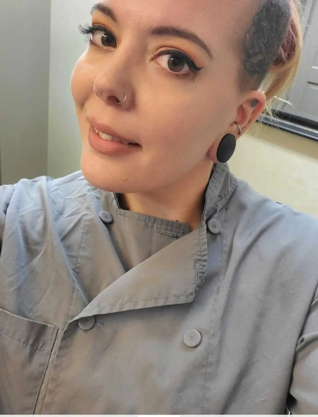 Pastry Chef Jess Demayo smiling in a gray kitchen jacket